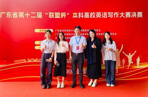 A group of people standing in front of a red wall Description automatically generated